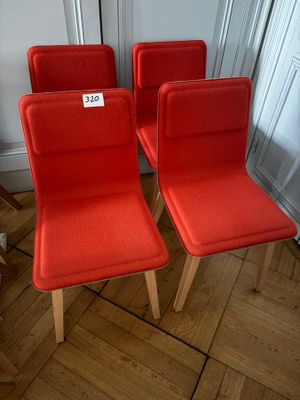 three red chairs with a price tag on them sitting on a wooden floor