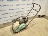 an image of a lawn mower parked in front of a wall
