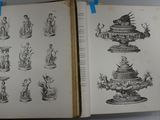 two open books with drawings on them on a table