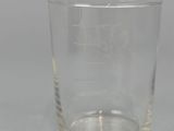 a glass with a logo on it sitting on a table