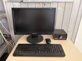 a computer monitor and keyboard on a desk in a room