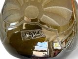 a glass vase with a flower on it on a table