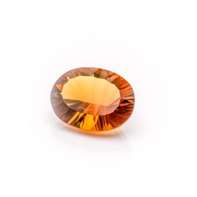a close up of a yellow sapphire stone on a white surface