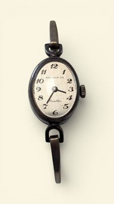 a black and white photo of a wrist watch on a white surface
