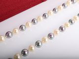 pearls and a red purse are on a white surface