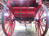 a red wagon with chains attached to it in a barn