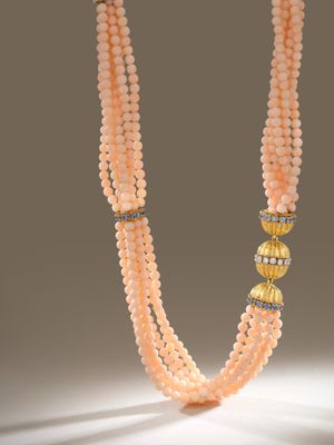 un gros plan d'un collier orné de perles sur un fond blanc