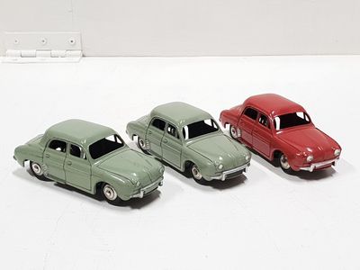 three toy cars sitting next to each other on a white surface