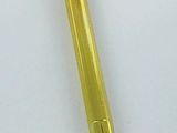 a close up of a gold pen on a white surface