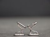 silver plated pair of scissors on a table with a black background