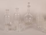 bottles and glasses are lined up on a white surface