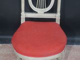 a white chair with a red seat on a carpeted floor
