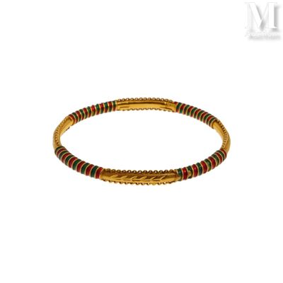 un gros plan sur un bracelet en or orné de perles rouges et vertes