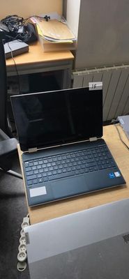 a laptop computer sitting on a desk next to a chair