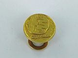 a gold bit coin sitting on top of a white surface