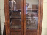 un grand meuble en bois avec des portes en verre dans une pièce