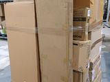des cartons empilés sur des palettes dans un entrepôt, avec des palettes en arrière-plan