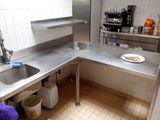 une cuisine équipée d'un évier et d'un plan de travail sur lequel est posée une assiette