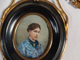 two framed portraits of a woman in a blue dress and a man in a blue shirt