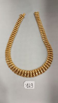 un collier à chaîne en or muni d'une plaque