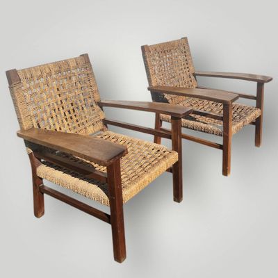 deux chaises en bois avec des assises tressées, sur fond gris