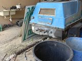 a blue machine that is sitting in the dirt