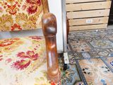 a wooden chair with a floral upholstered cushion on it