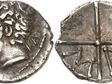 a close up of a silver coin with a face on it