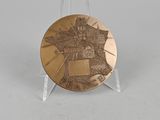 bronze plate with a picture of a castle on it on a clear stand
