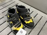 une paire de chaussures noires et jaunes posées sur une table en bois