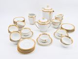 a lot of white and gold dishes and cups on the table