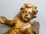 a gold statue of an angel with wings on a table