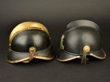 pair of black and gold fire helmets on a black background