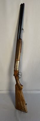 un vieux pistolet avec une poignée en bois sur une surface blanche