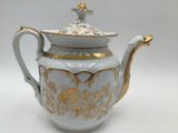 a white and gold tea pot with a gold lid