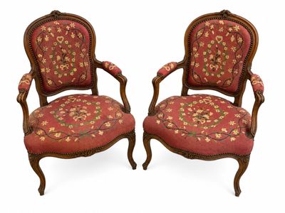 paire de fauteuils en noyer sculpté de style Louis XV, recouverts de tissu rouge