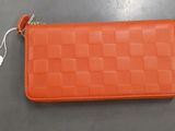 un petit portefeuille orange muni d'une étiquette