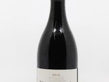 la bouteille de vin est posée sur une surface blanche