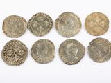 a group of six silver and gold coins on a white surface
