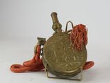 a small gold coin with a red cord around it