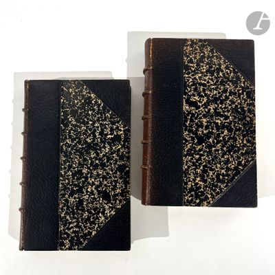 two black and gold books sitting next to each other on a white surface