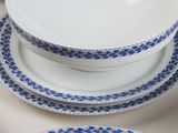 a white plate with blue flowers on it next to a bowl and a plate on a table