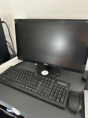 un ordinateur de bureau posé sur un bureau, à côté d'un ordinateur portable