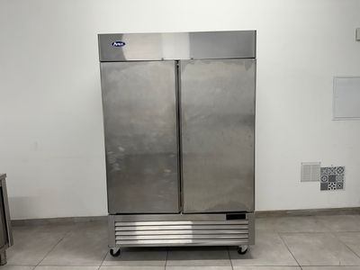 réfrigérateur à double porte en acier inoxydable dans une cuisine professionnelle dotée d'un sol carrelé