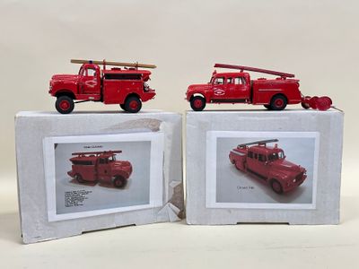 deux camions de pompiers rouges posés sur une boîte blanche