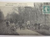 an old photo of a group of people walking down a dirt road