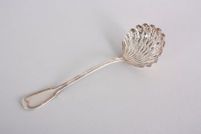 silver spoon with a leaf shaped handle on a white surface