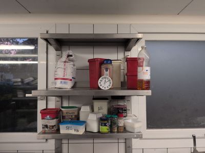a metal shelf with various items on it in a kitchen