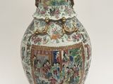 a vase with a painting on it sitting on a table