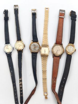 quatre types de montres sont alignés sur une surface blanche